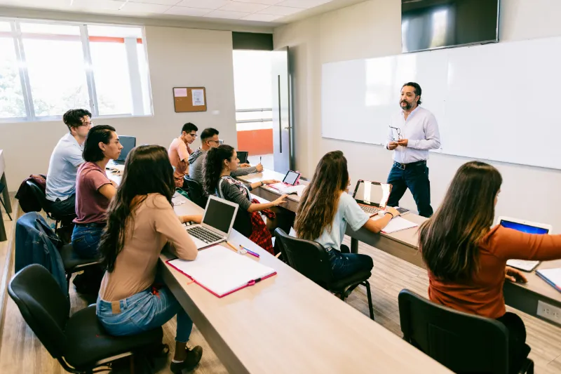Docente impartiendo clase a su grupo en un aula de una institución educativa mexicana