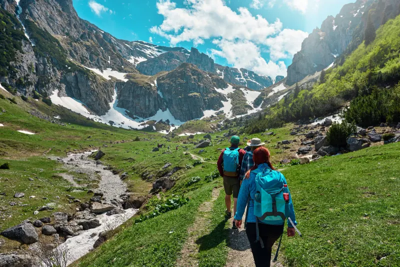 Pareja haciendo senderismo por un valle de montaña